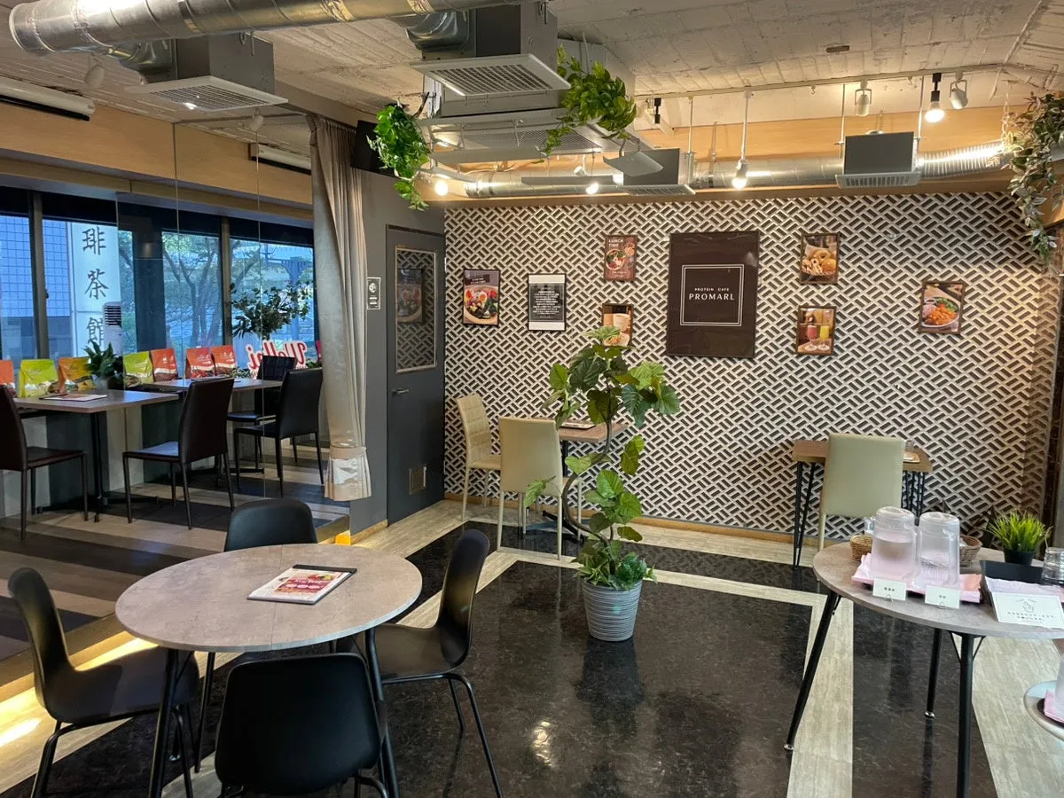 店内を写した写真。テーブル席と壁の装飾が特徴的で、観葉植物が配置されている。