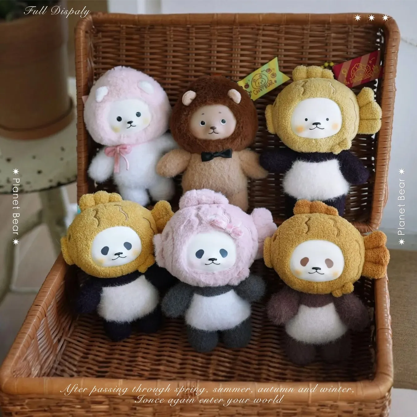 バスケットの中に、様々な動物の着ぐるみを着た可愛らしいぬいぐるみたちが並んでいる写真です。ピンクのクマ、ライオン、パンダ、金魚など、多様なデザインのぬいぐるみが、温かみのある雰囲気を作り出しています。