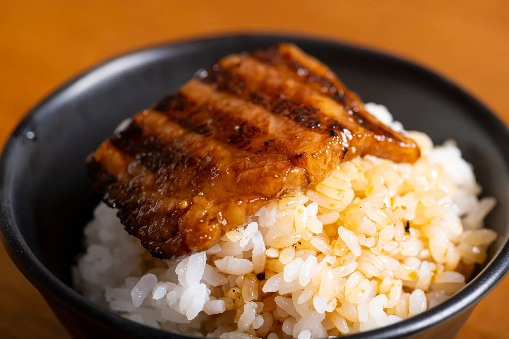 ご飯の上に照り焼きされた肉が乗っている写真