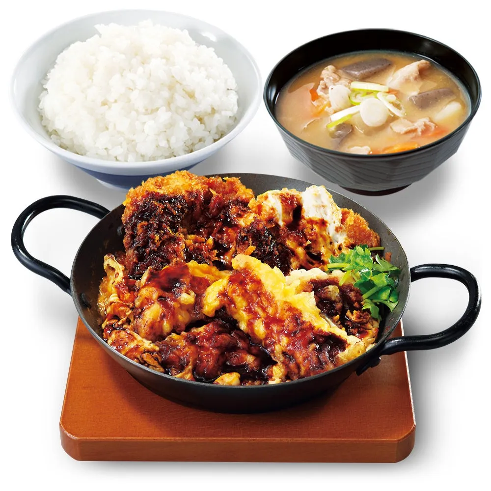 揚げ物と卵でとじられた料理、ご飯、味噌汁がセットになった日本の定食の写真です。