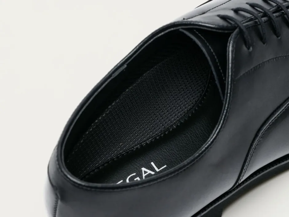 黒い革靴のクローズアップ写真。靴の内側、インソール、ステッチ、レースが写っています。