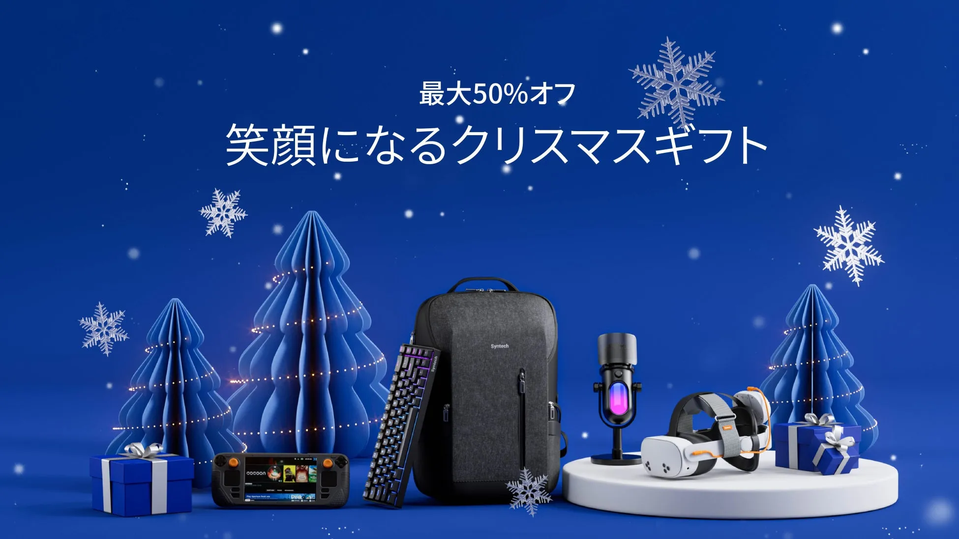 青い背景に、クリスマスをテーマにしたギフトが並べられた画像です。「最大50%オフ 笑顔になるクリスマスギフト」という文字が上部に配置されています。画像には、クリスマスツリー、プレゼント、ゲームコントローラー、バックパック、キーボード、マイク、VRヘッドセットなどが含まれています。