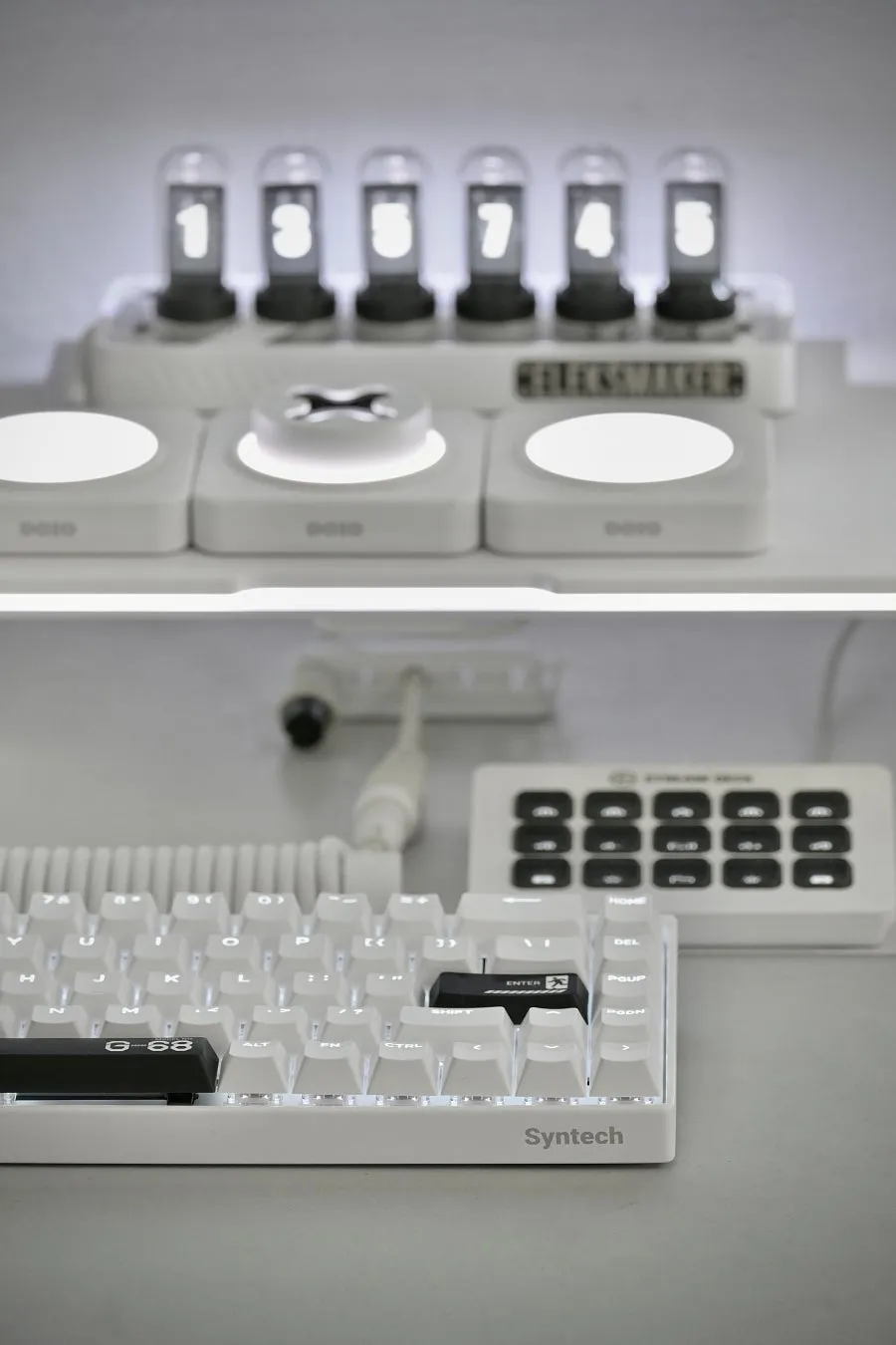 白いキーボード、数値が表示されたディスプレイ、複数のボタンを備えたデバイスが写っています。キーボードには Syntech のロゴが、ディスプレイには Helixmaker の文字が確認できます。