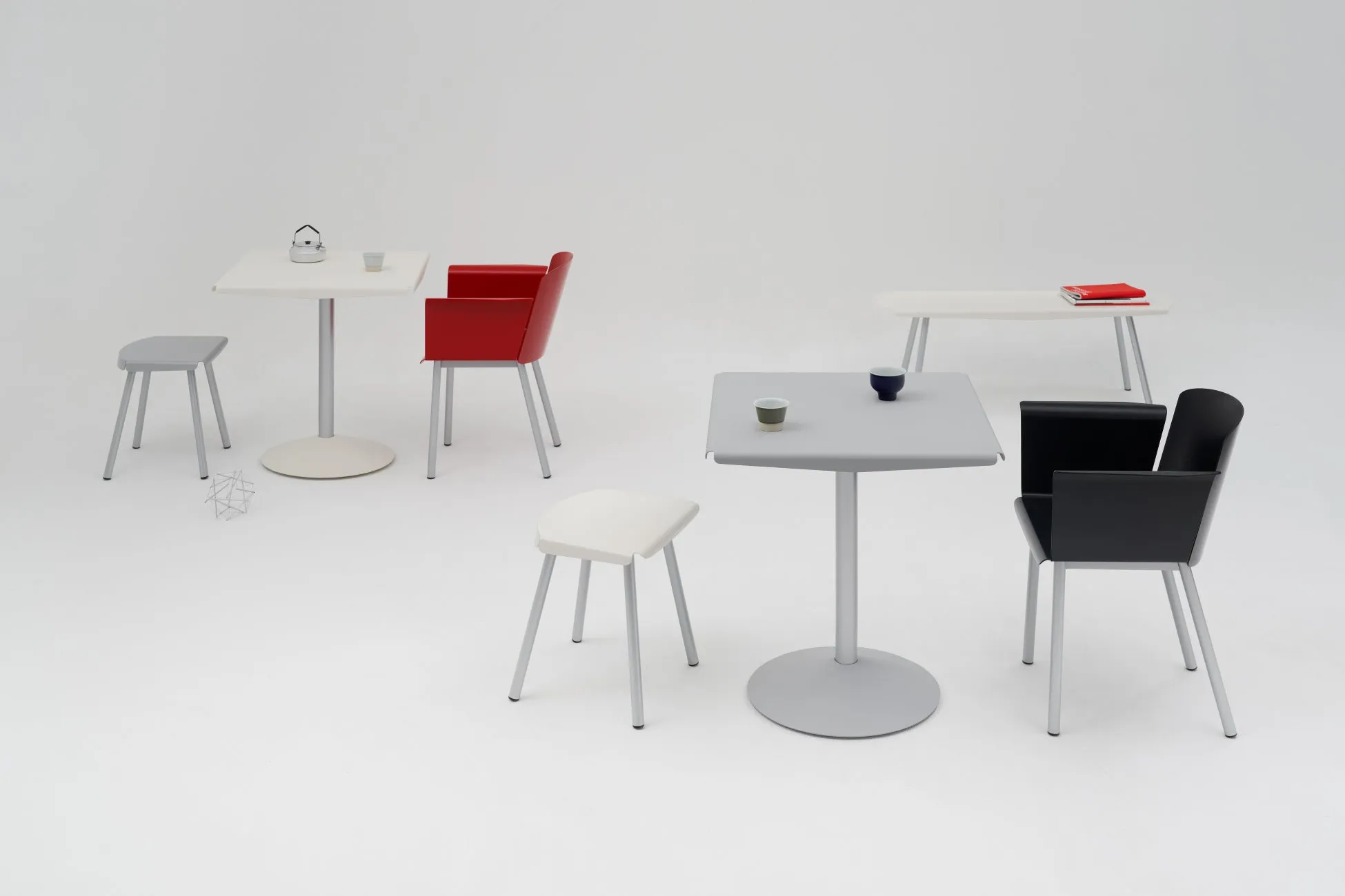白い背景に、様々な色の椅子とテーブルが配置された写真。