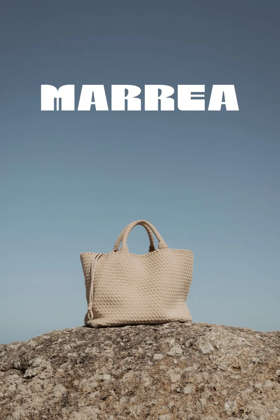 空の下、岩の上に置かれたバッグの広告画像です。