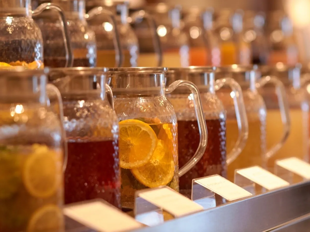 さまざまなフレーバーのドリンクが入ったガラスピッチャーの列