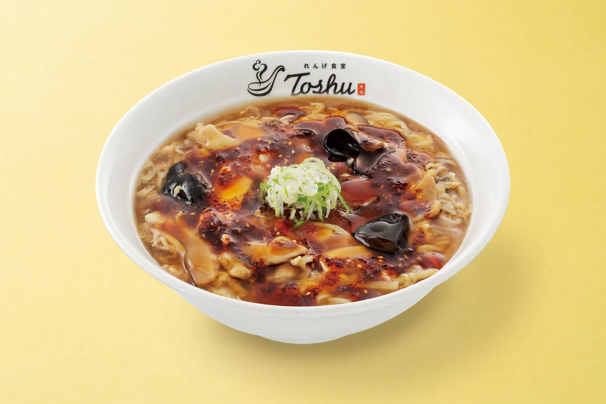 白い器に入った中華料理。具材はキクラゲ、ネギ、卵、麺など。