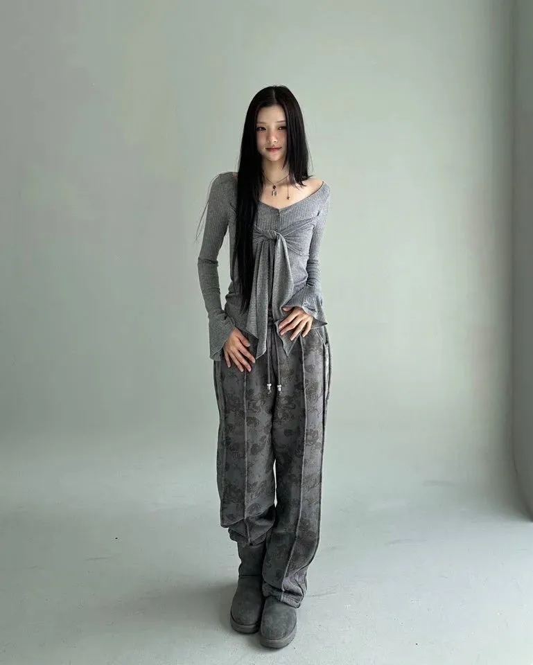 グレーのトップスとパンツのセットアップの女性