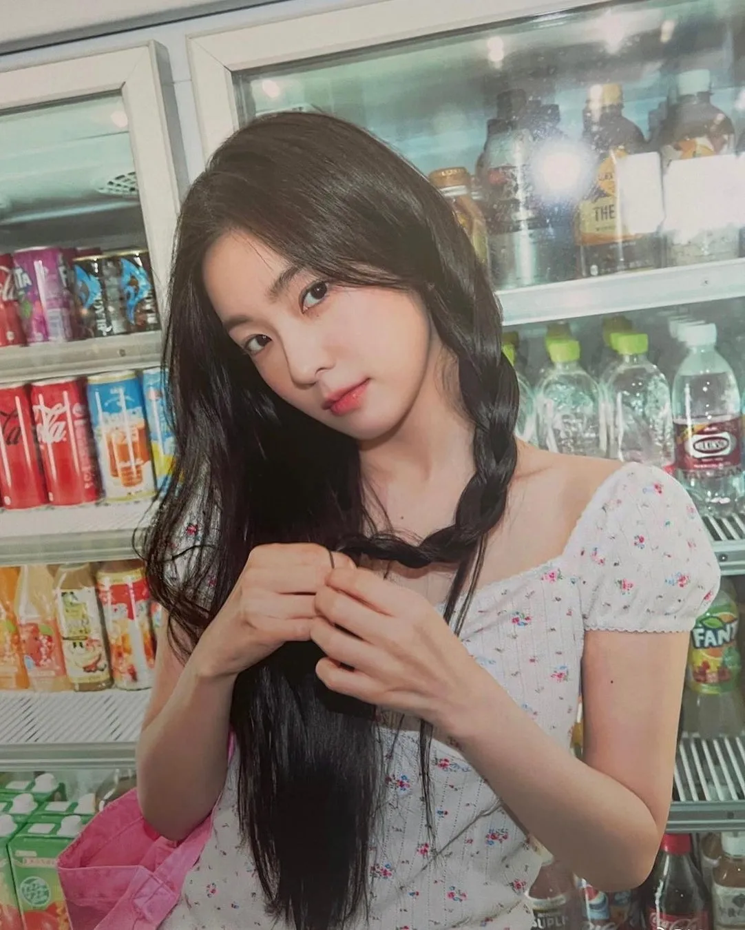 三つ編みで花柄トップスの女性