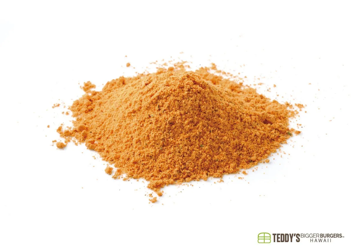 白い背景にオレンジ色の粉末状のスパイスの山。