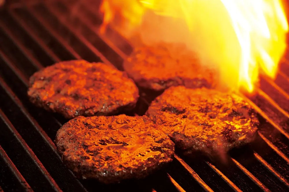 焼き網の上で焼かれているハンバーグのクローズアップ写真です。