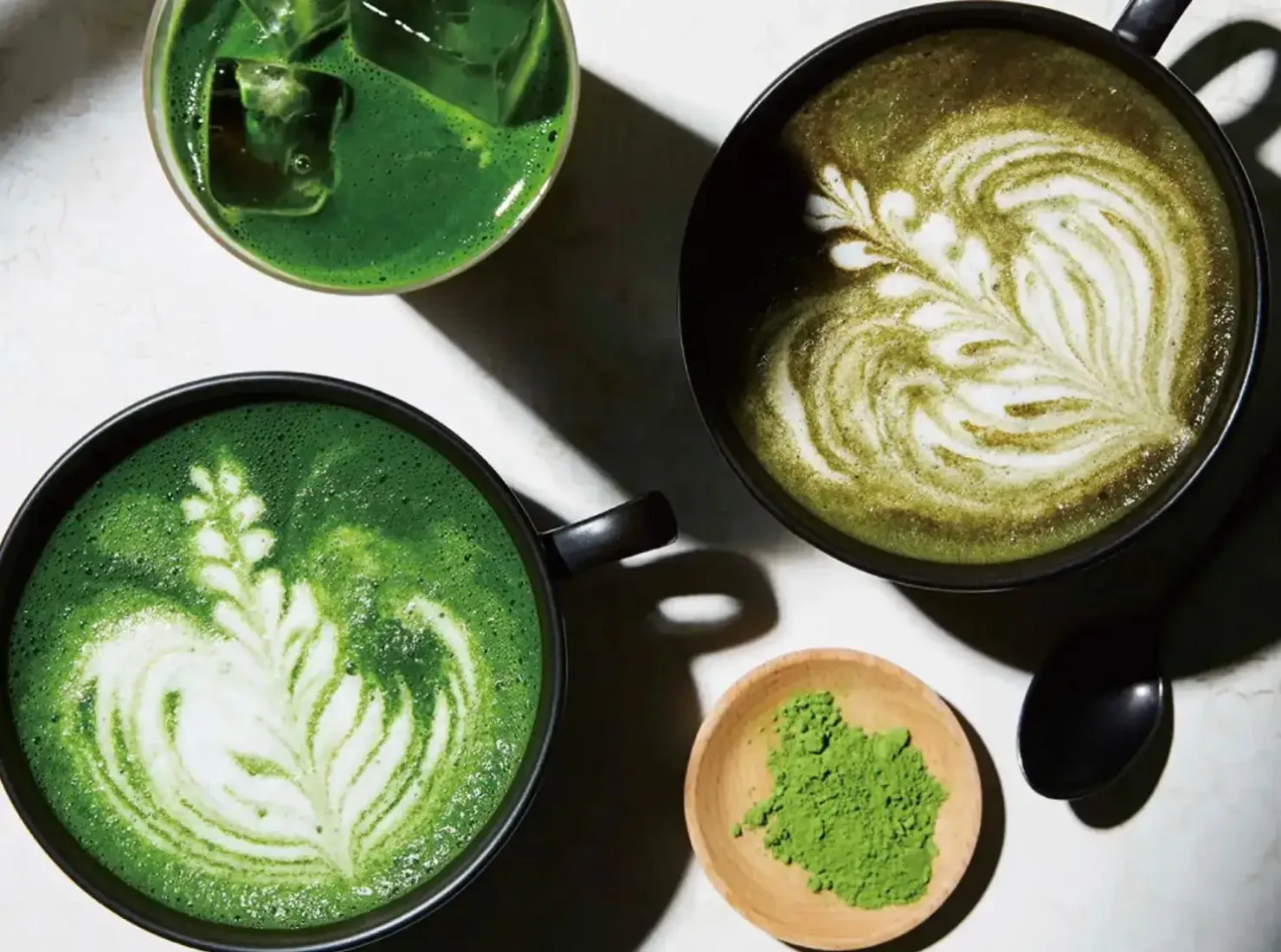 抹茶ラテと抹茶パウダーの入った木製の器の写真です。