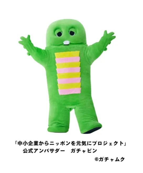 緑色のキャラクター「ガチャピン」が立っている画像。