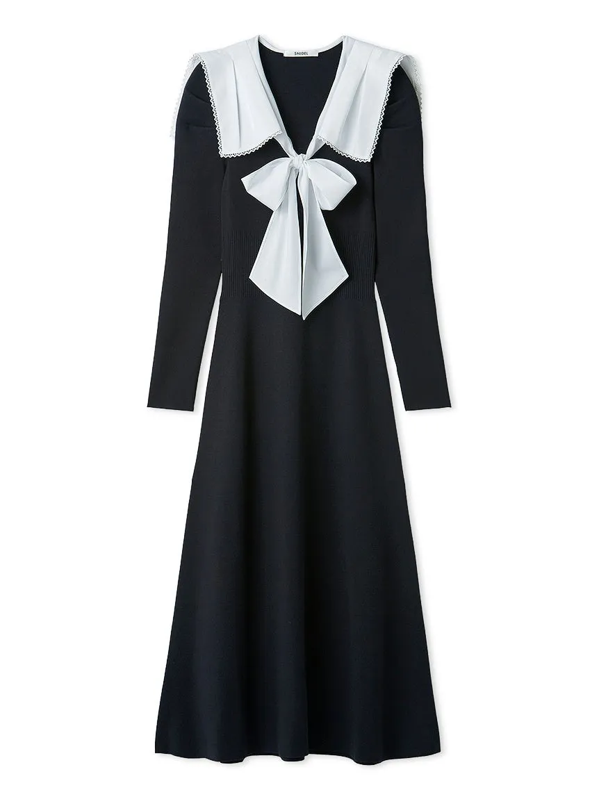 黒色のワンピース。襟と胸元に白いリボンとフリルが付いている。