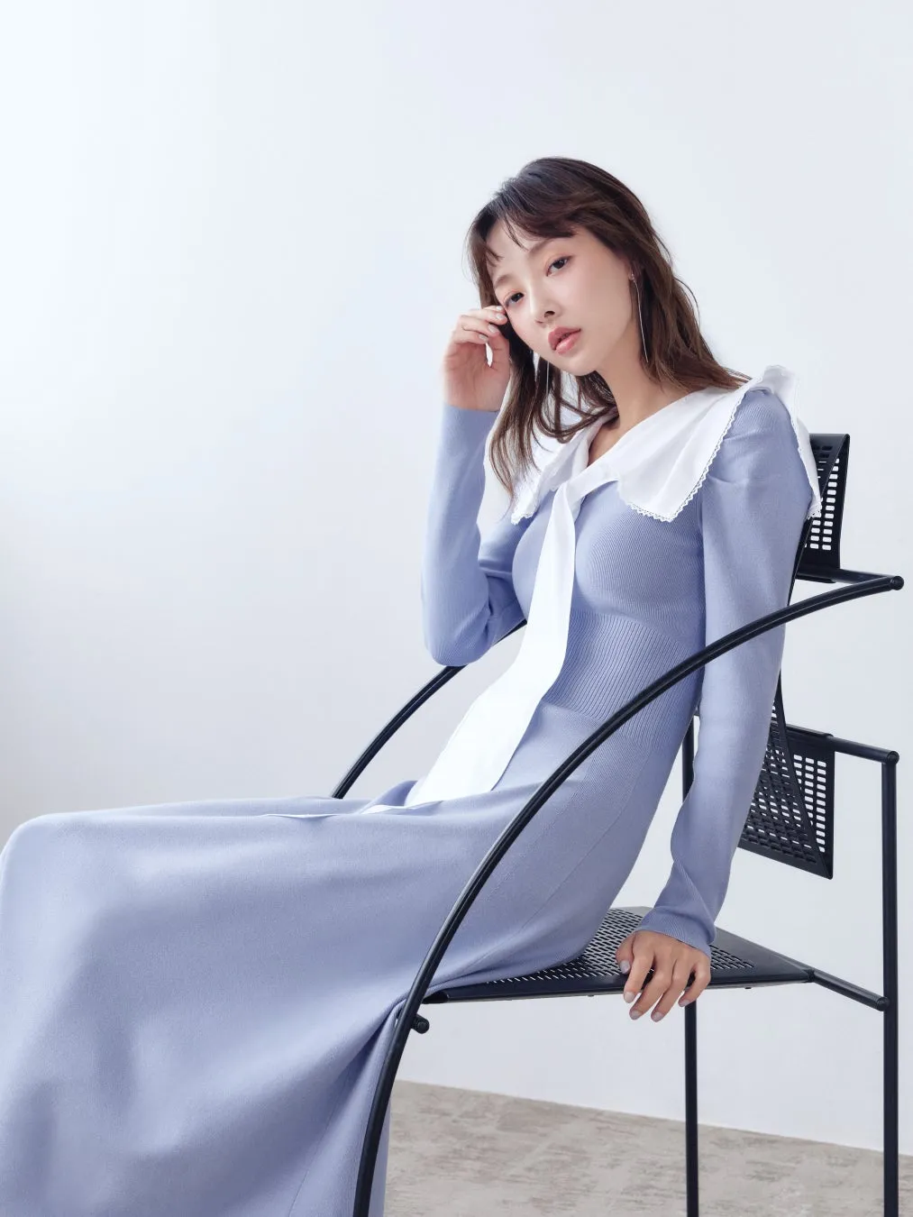 女性が椅子に座ってポーズをとっている水色のドレス