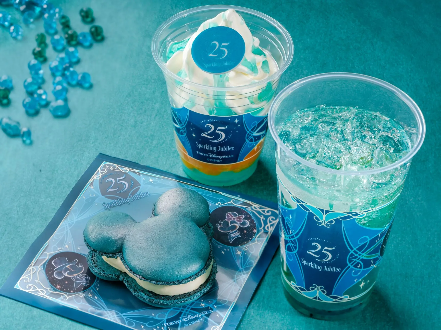ディズニーシー25周年記念の青を基調としたデザートセットの写真。ミッキーシェイプのマカロン、ソフトクリーム、ドリンクが写っている。