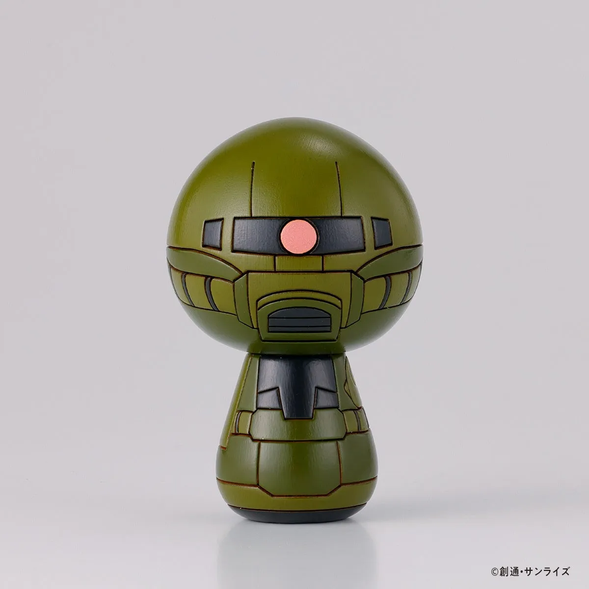 緑色のロボットのフィギュア。ロボットの頭部は丸く、目はピンク色で、胴体は細長い。