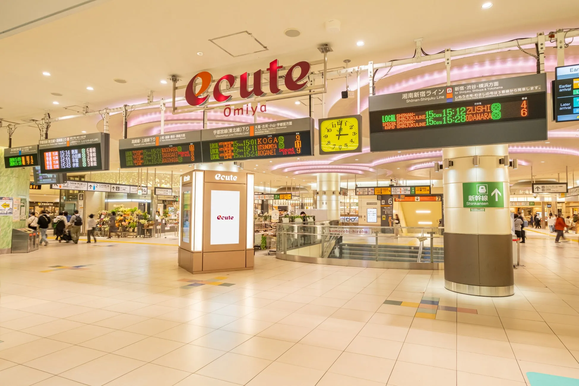 電光掲示板や時計、駅構内の様子が写っている写真。駅名や電車の発着情報が表示されている。