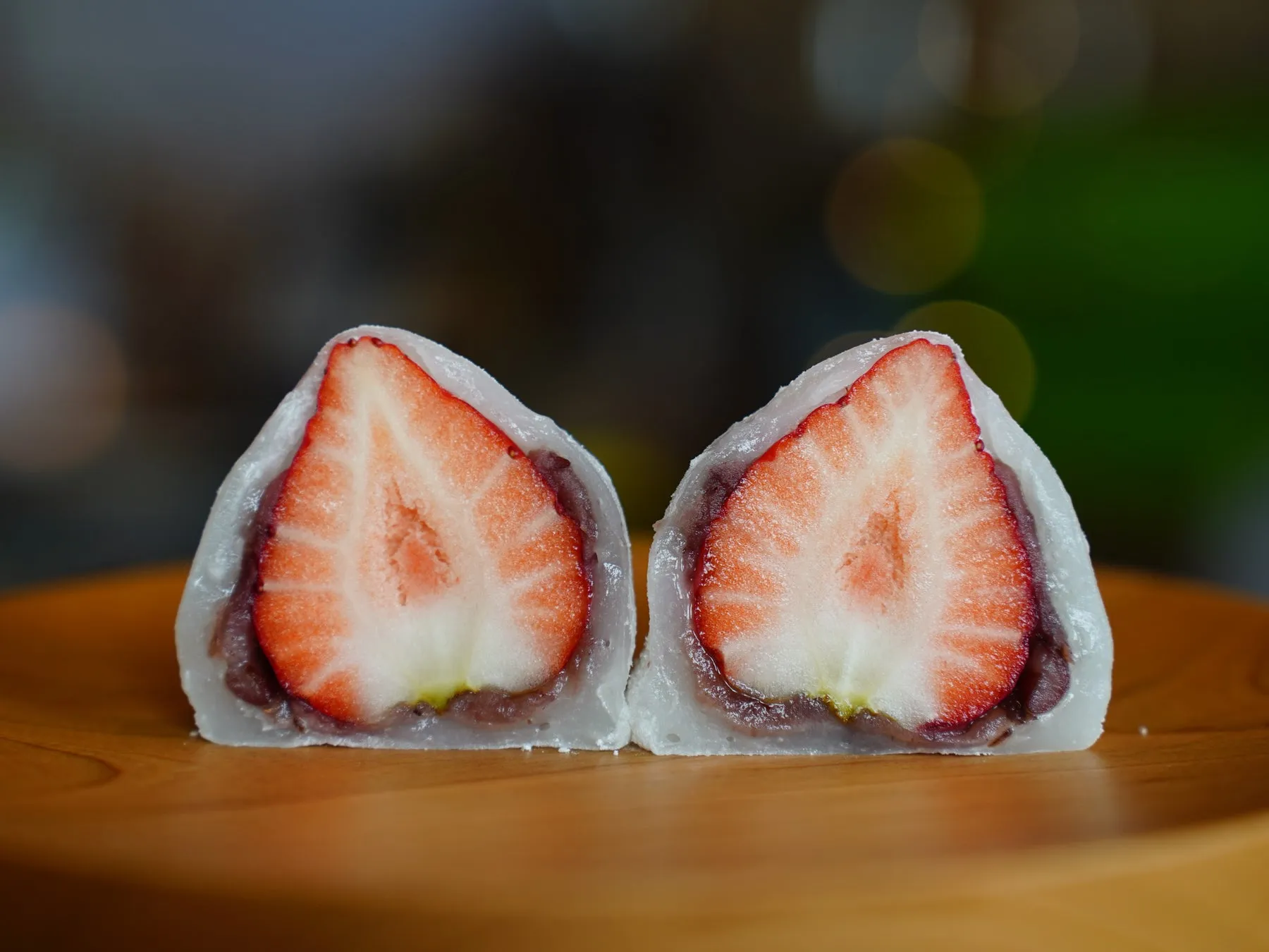 いちご大福が2つ並んだ写真です。断面が写っており、鮮やかな赤色のイチゴと餡が見えます。