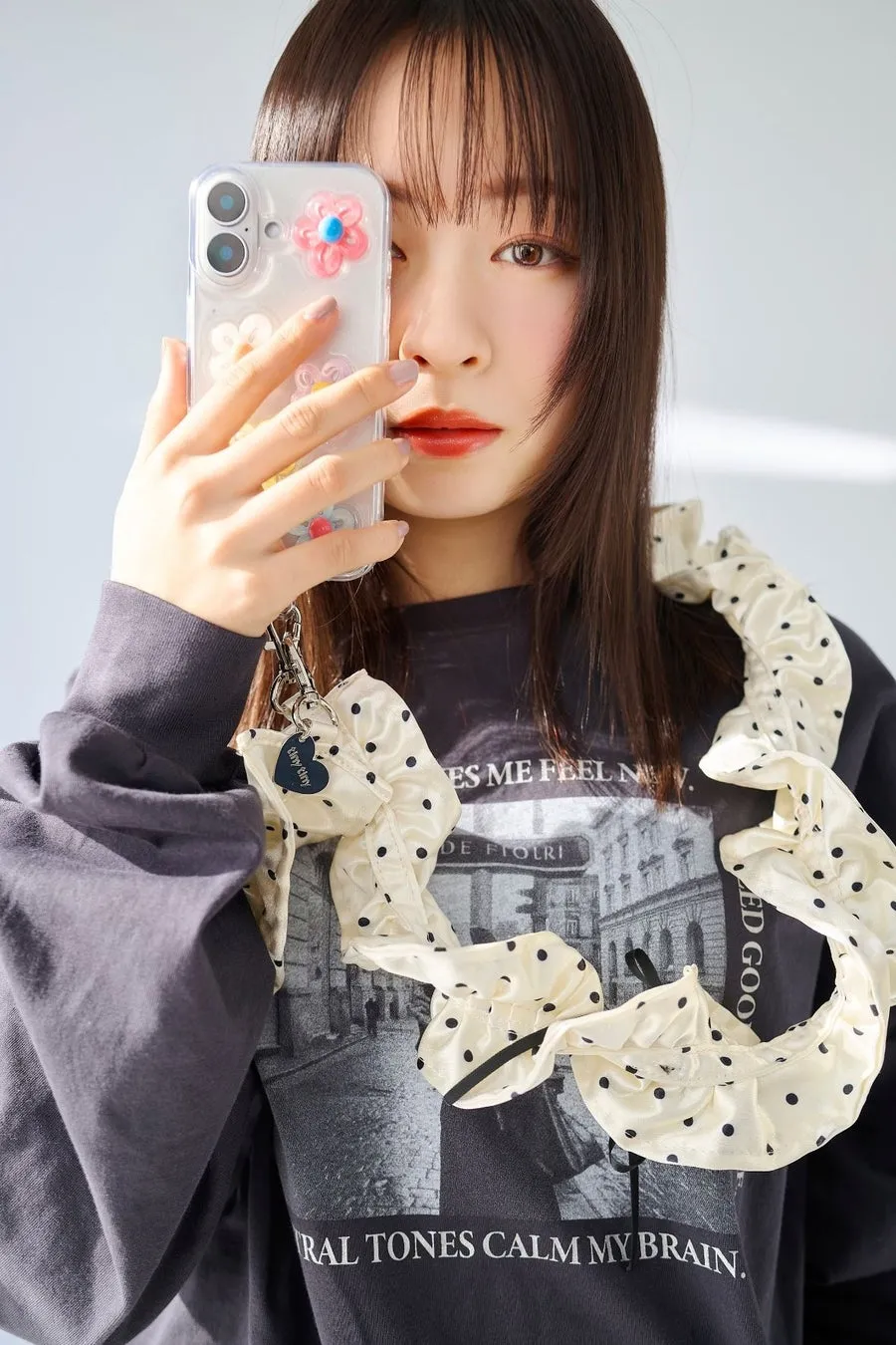 女性がスマートフォンを持ち、顔を隠すように撮影している。