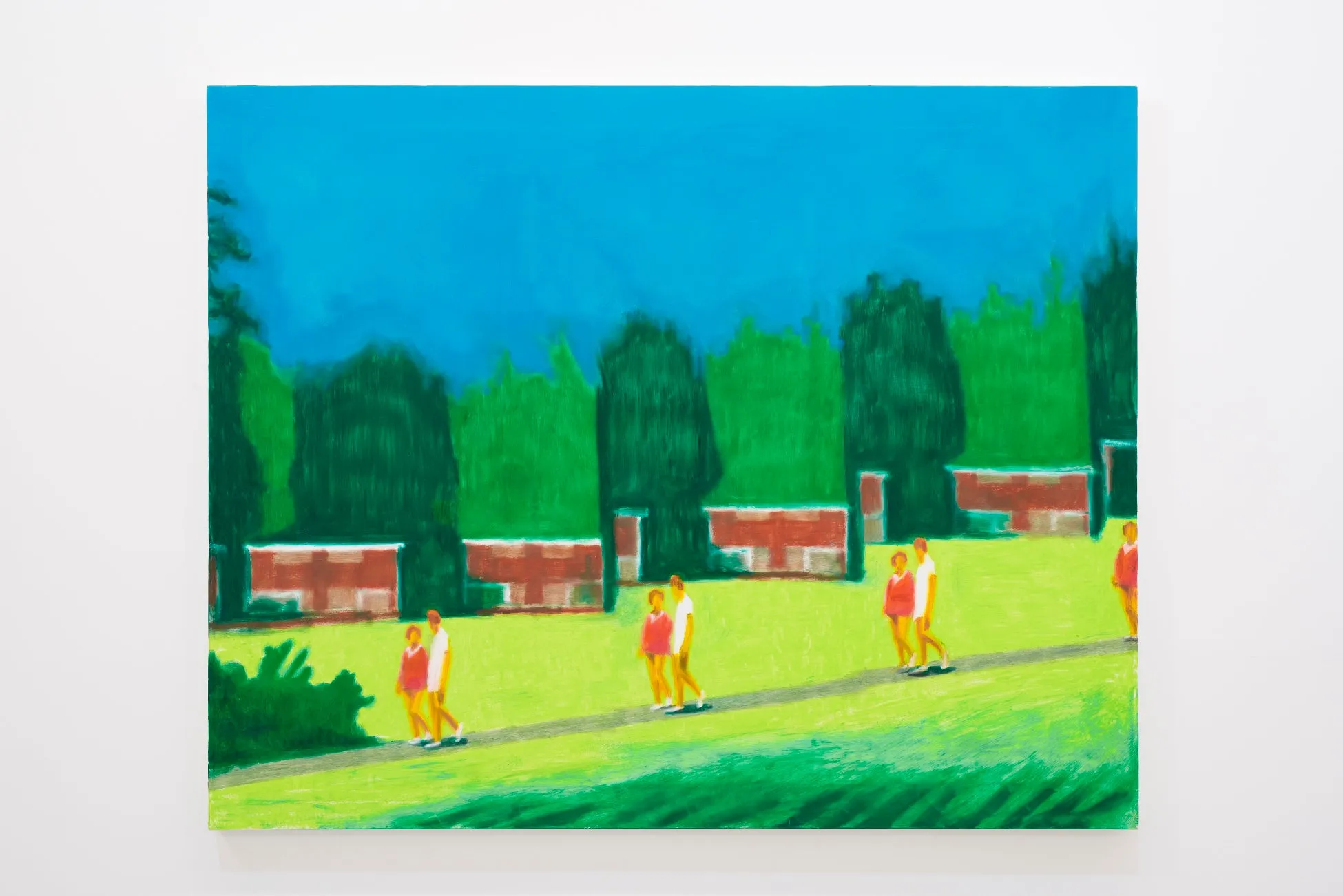 芝生の上を歩く人物、レンガの建物、木