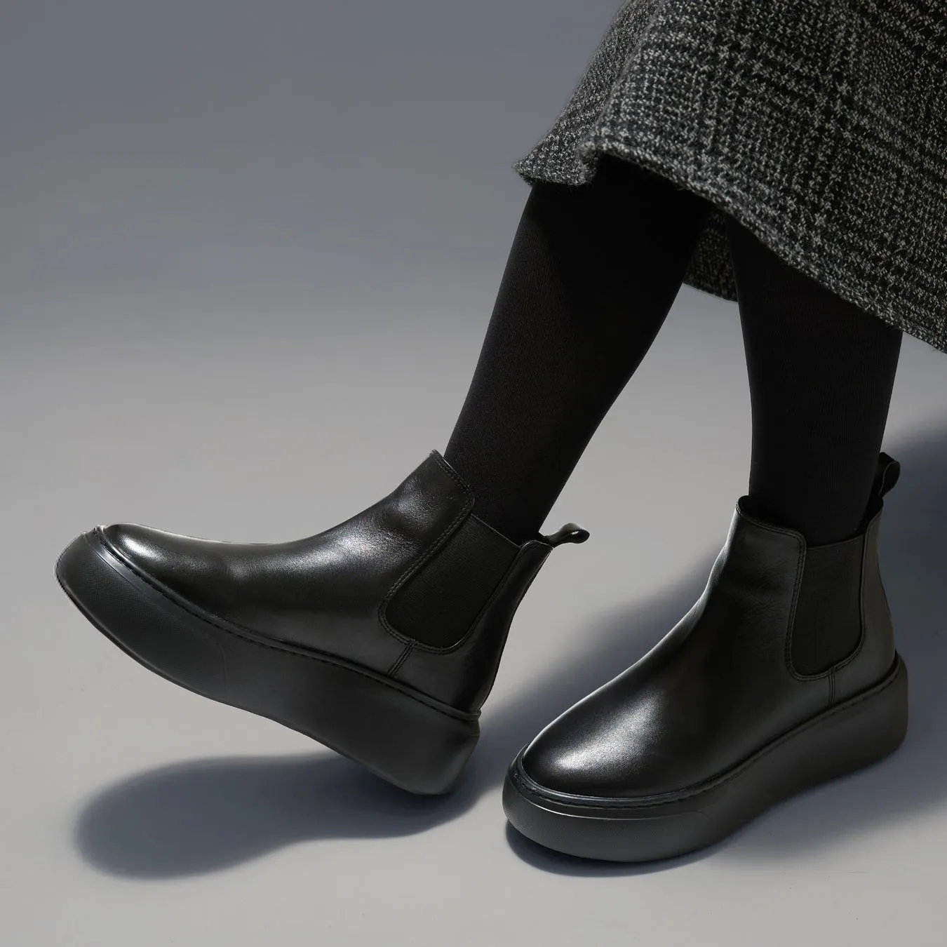 黒いプラットフォームブーツを履いた女性の足元クローズアップ