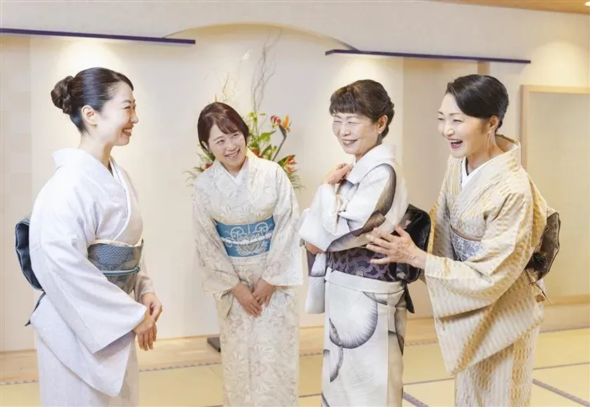 着物姿の女性4人が笑顔で談笑している様子