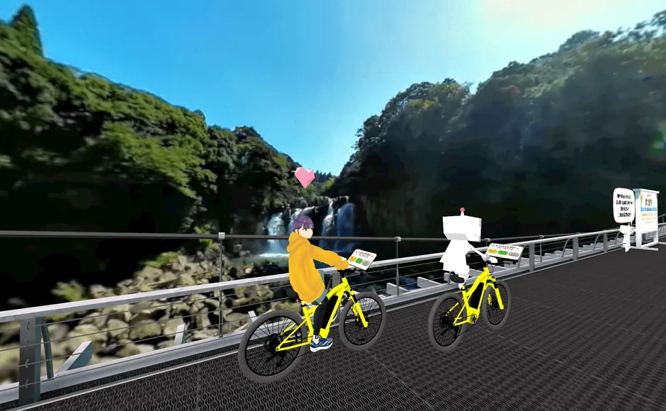 橋の上を自転車に乗って進む2人のキャラクター。背景には滝と緑豊かな山々が広がり、青い空が晴れ渡っている。