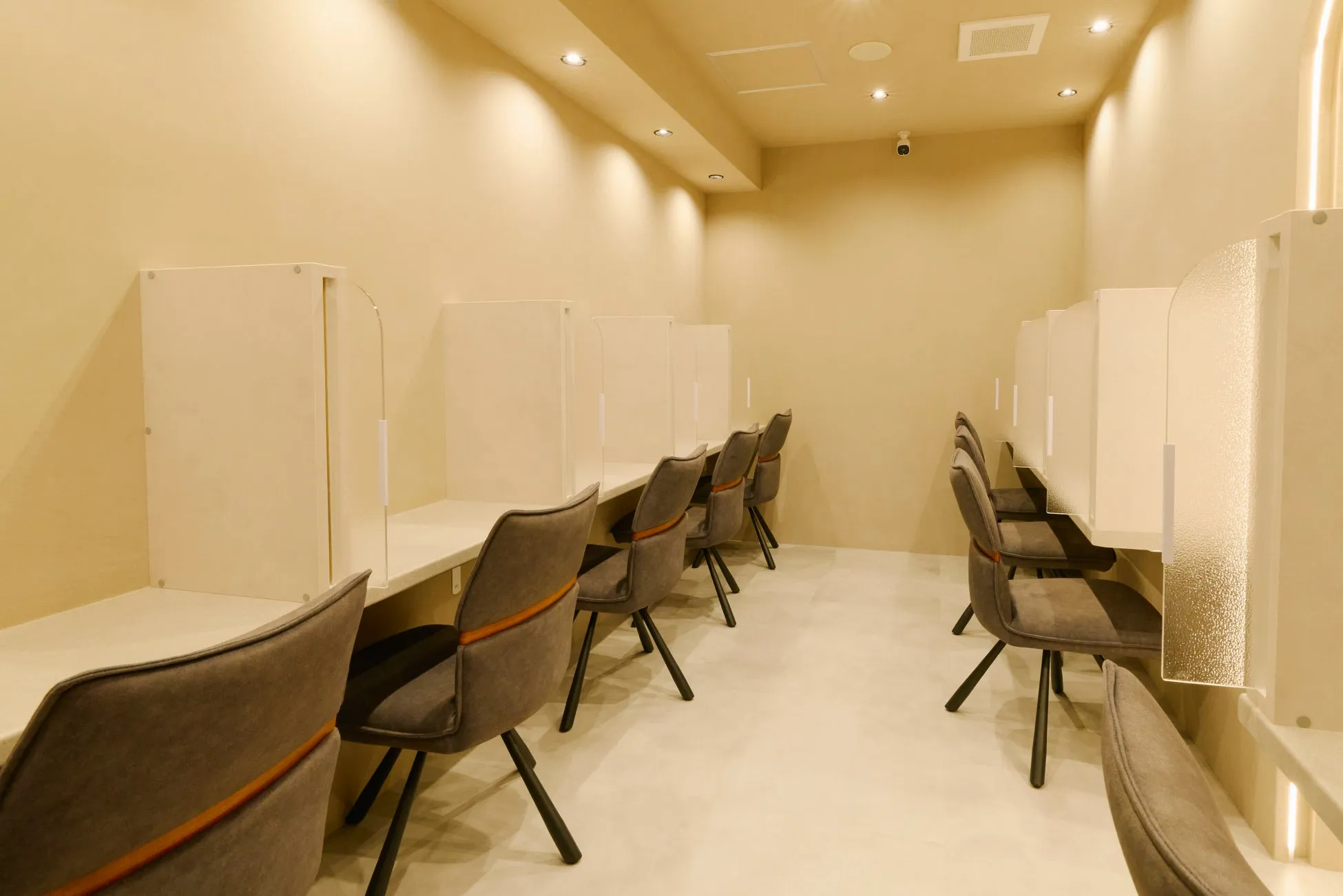 学習塾またはオフィスのような内装の画像です。パーテーションで区切られたデスクと椅子が並んでいます。