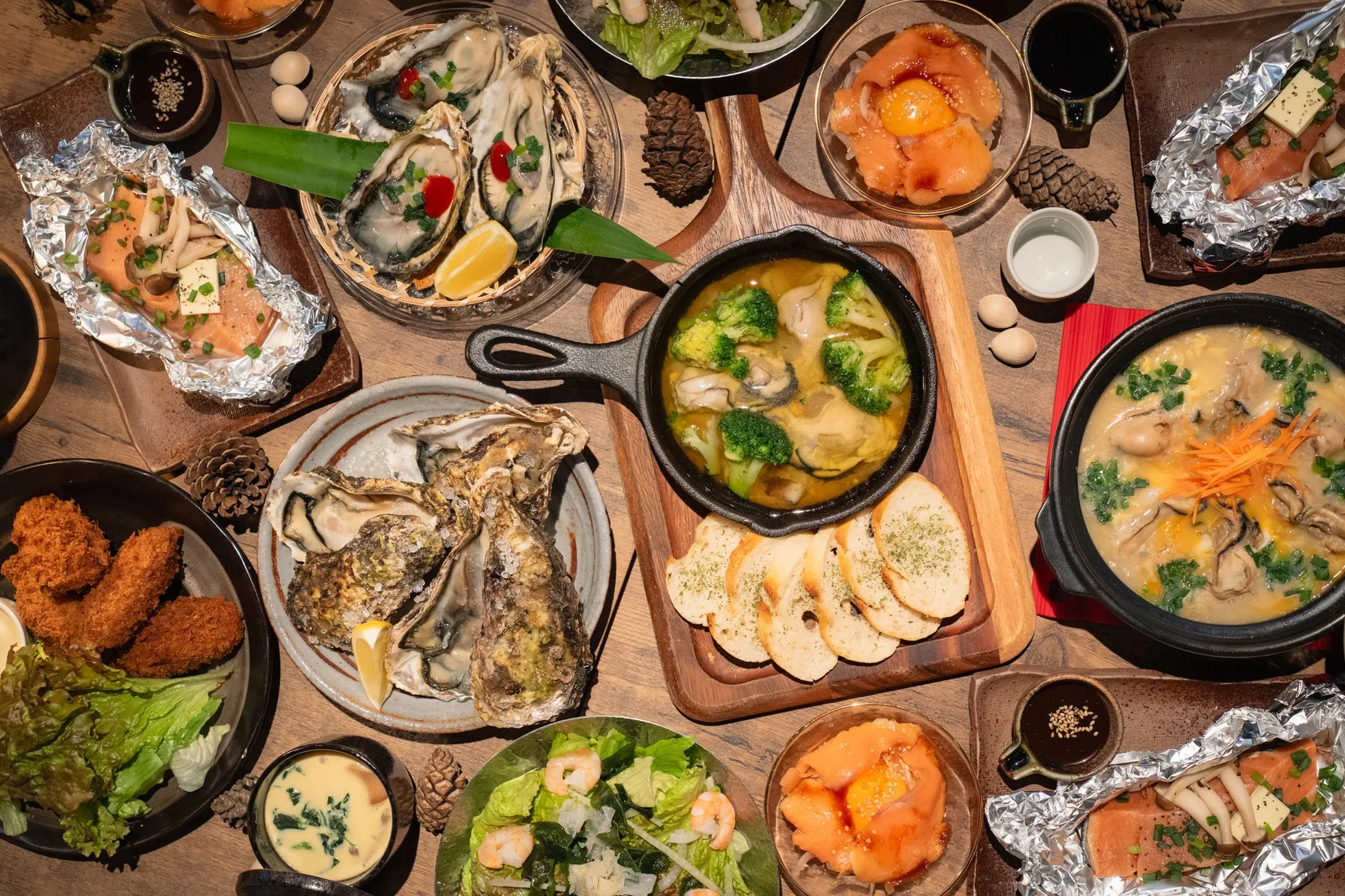 テーブルいっぱいに並んだ、牡蠣やサーモン、野菜などを使った様々な料理