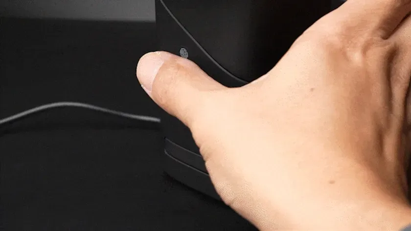 黒い物体に手を置いている様子