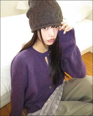 紫色のカーディガンとニット帽の女性