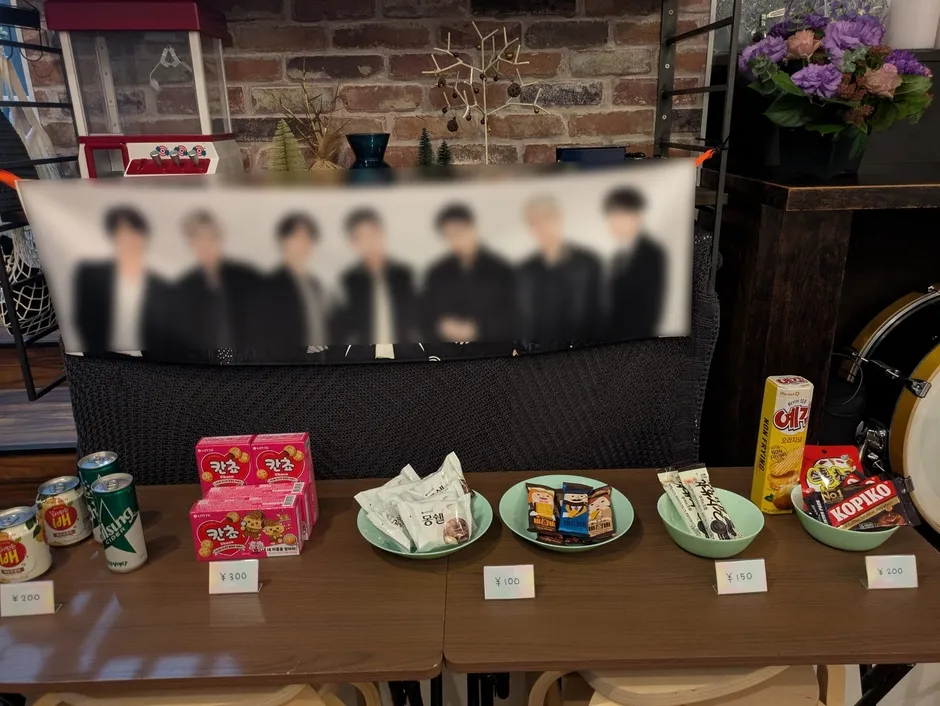 お店のテーブルに並ぶお菓子と飲み物、K-POP写真