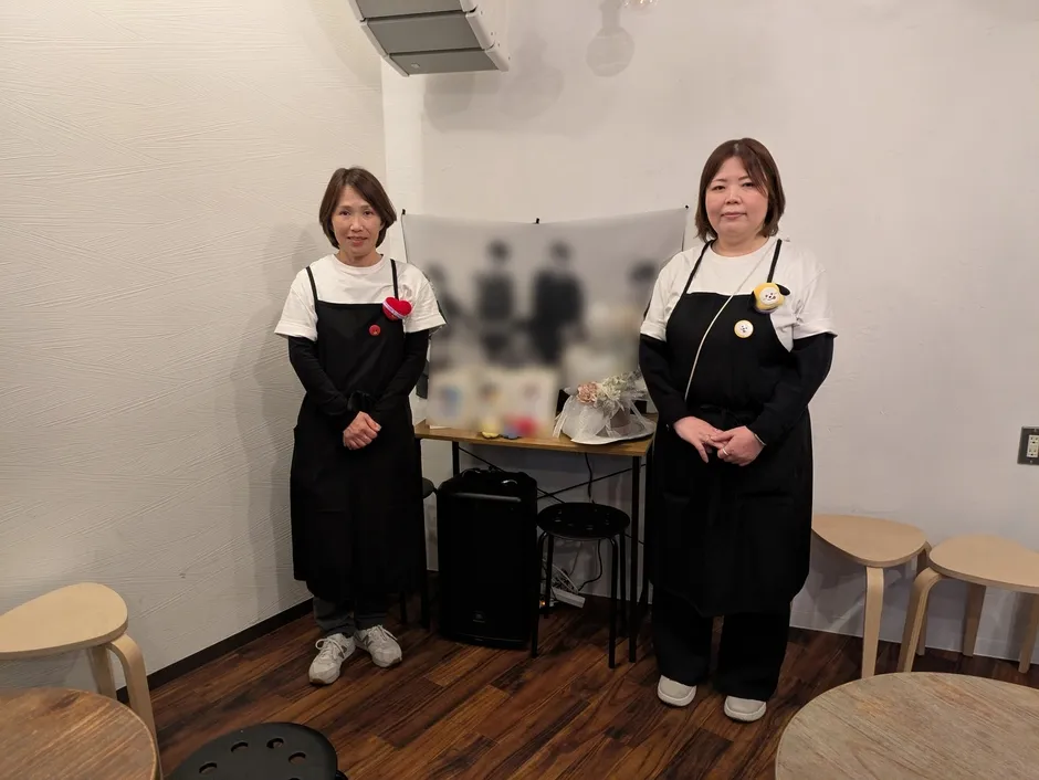 黒いエプロンを着た2人の女性