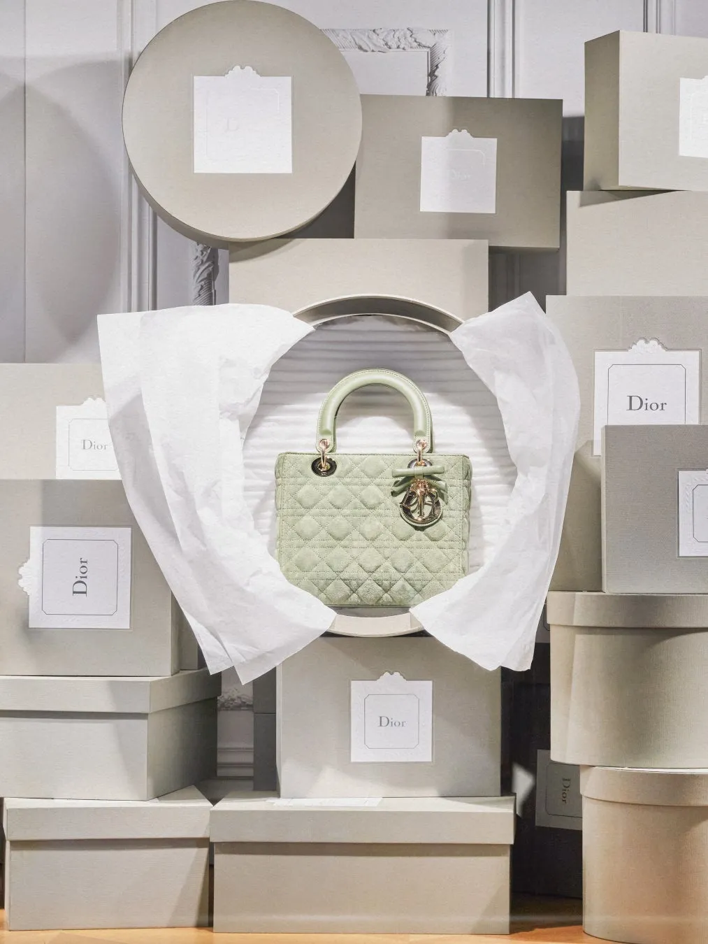ディオールのハンドバッグが、たくさんの箱に囲まれて展示されている様子。