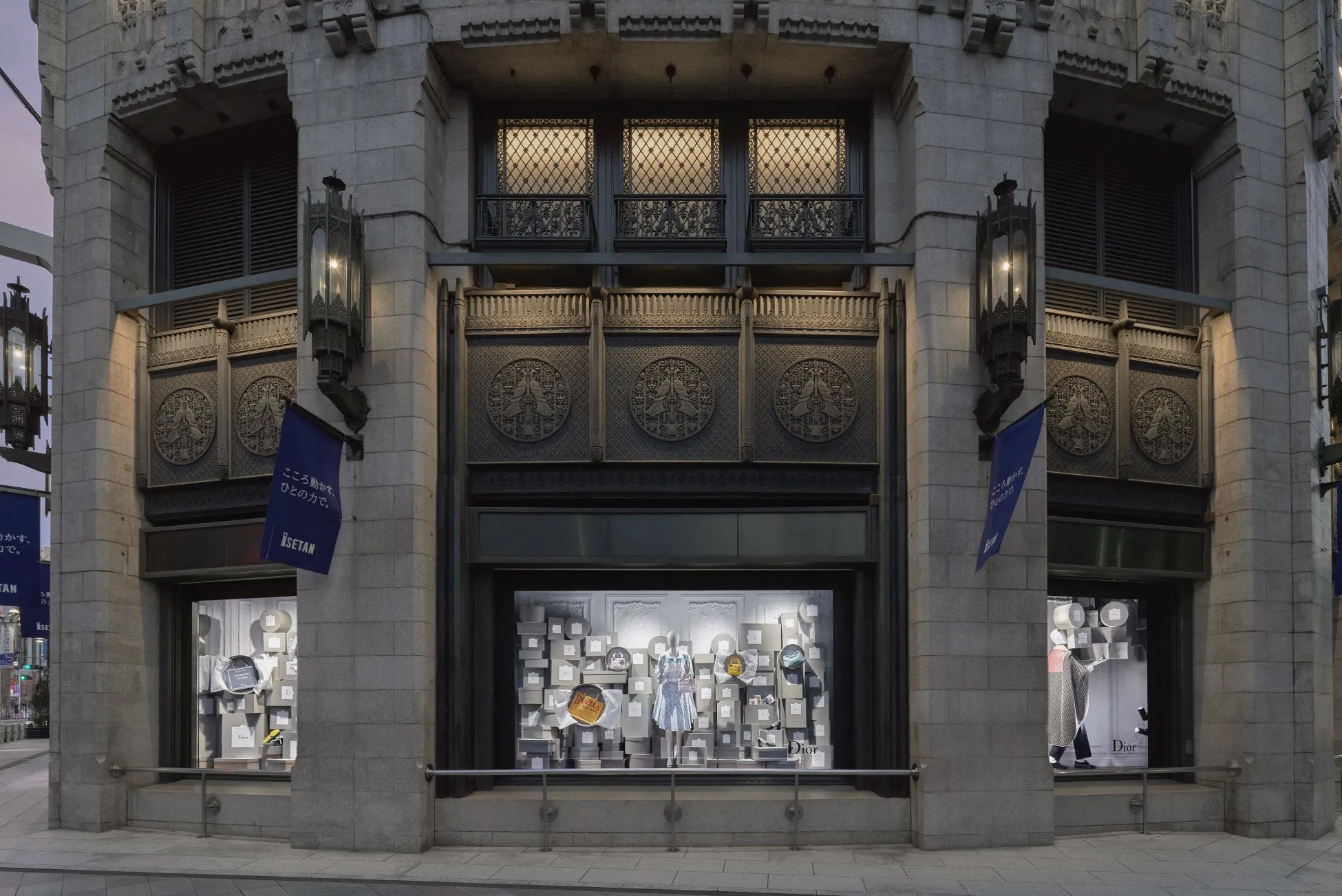 伊勢丹の店舗の外観。ショーウィンドウにはDiorの商品が並び、マネキンが配置されている。店舗の壁面にはレリーフが施され、青い旗には「こころ動かす、ひとの力で。」の文字が見える。