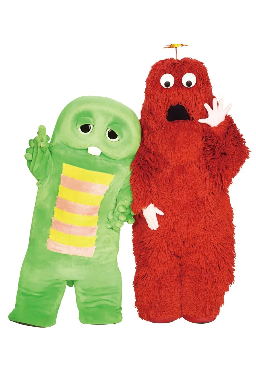 緑と赤のモフモフしたキャラクターが一緒に立っている画像です。緑のキャラクターは黄色とピンクのストライプ模様があり、手を上げています。赤のキャラクターは驚いた表情で手を上げています。