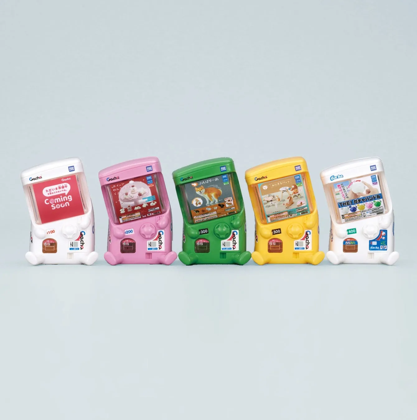 5台のガチャガチャが並んだ写真。それぞれのガチャガチャには、異なるキャラクターやアイテムが入っていることが示唆されている。