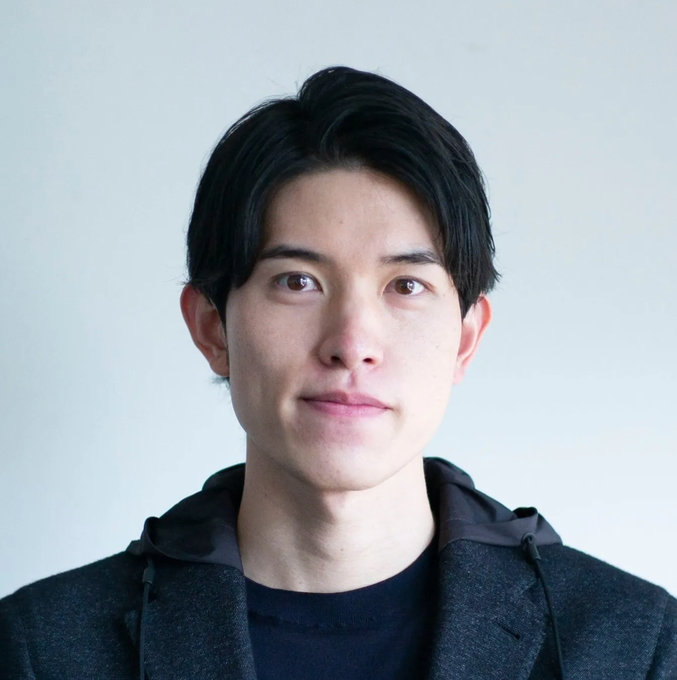 正面を向いて微笑んでいる若い男性のポートレート