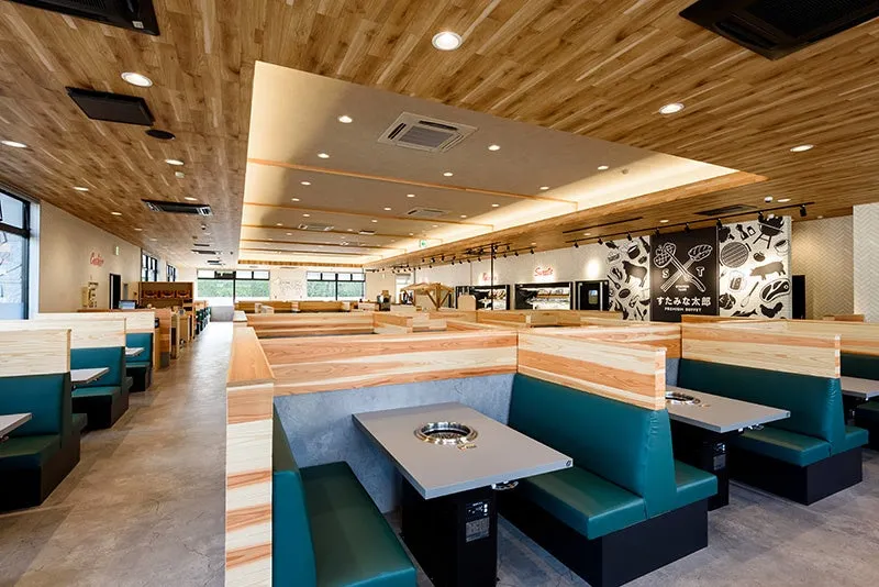 すたみな太郎の店内。テーブル席と木製の壁、天井が特徴的。