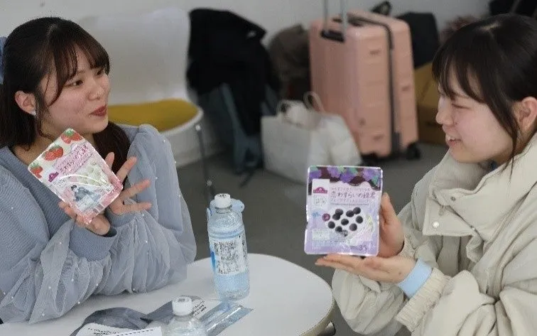 テーブルでお菓子を囲む学生たち