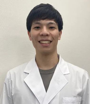 白衣を着た若い男性の笑顔のポートレート。