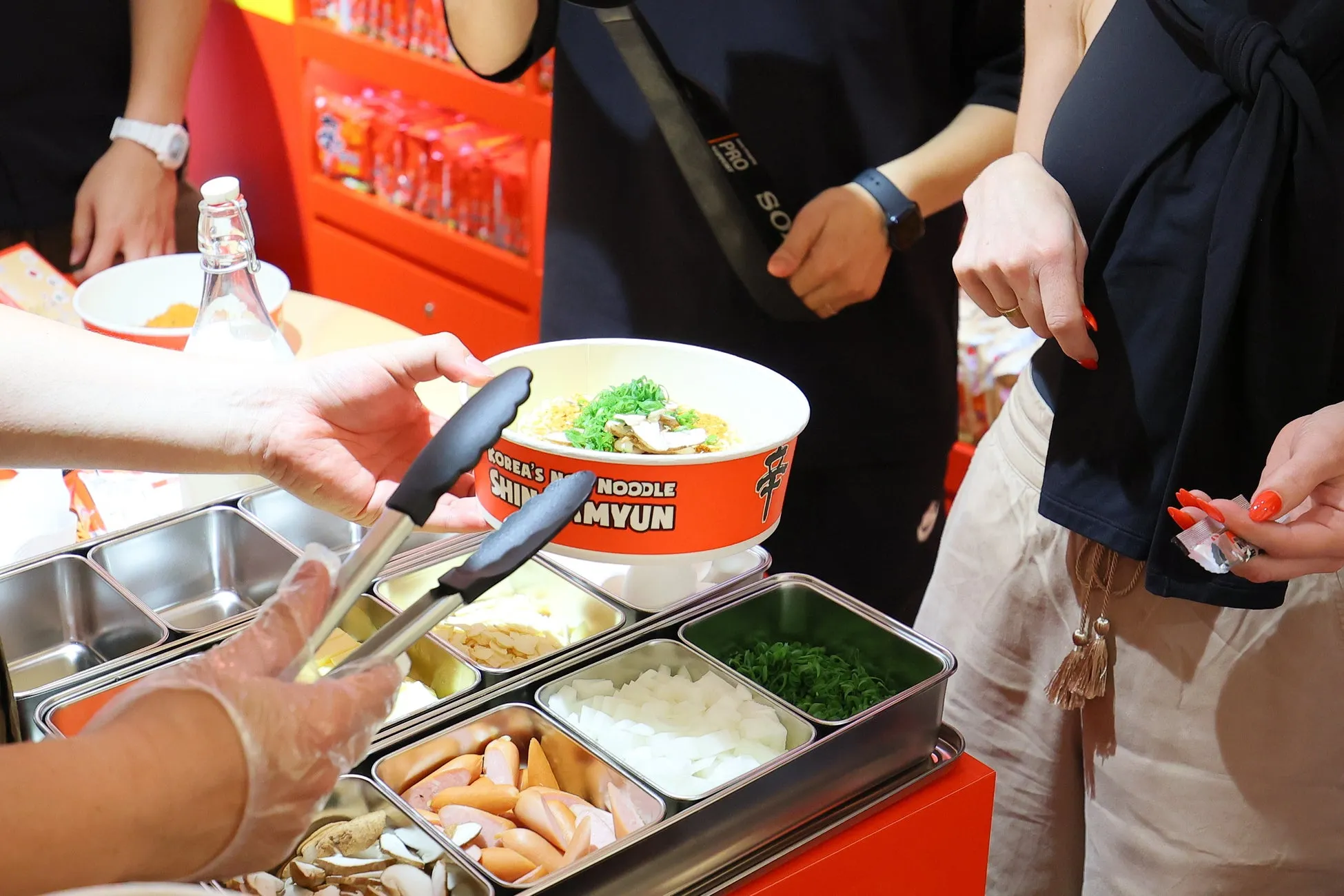 ラーメンをトングで取り分ける様子