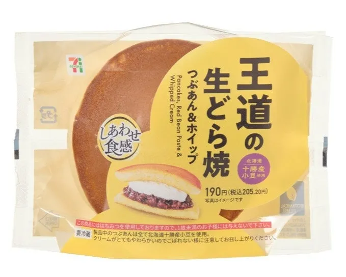 セブンイレブンの生どら焼きの商品パッケージ。どら焼きが半分見えており、パッケージには「王道の生どら焼」と書かれている。