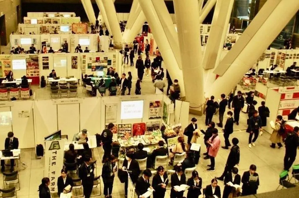 展示会会場の様子。多くの人が集まり、様々なブースが設けられています。