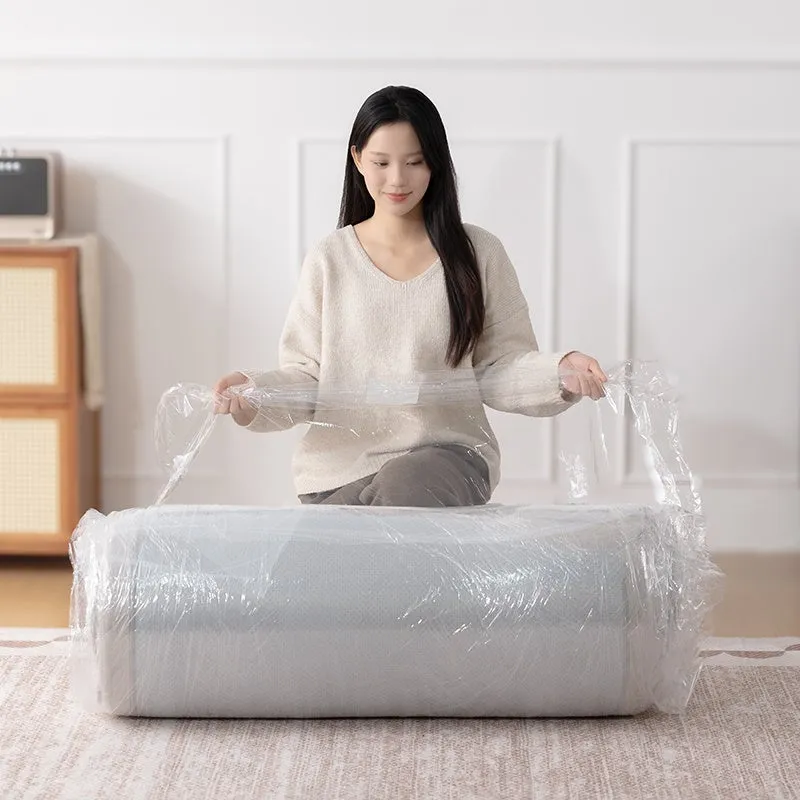 女性がロール状に梱包されたマットレスのビニールを剥がしている様子。