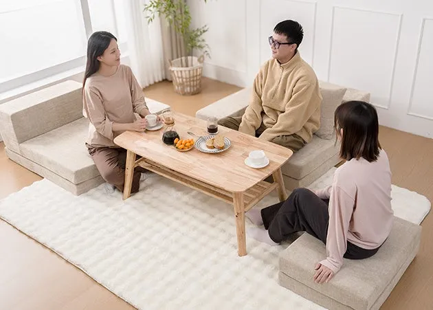 3人の人々が座って、テーブルを囲んでお茶を飲んでいる様子を描いた写真です。