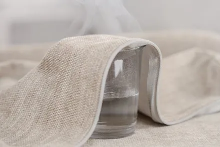 グラスに入った水が布に覆われ、湯気が立っている様子