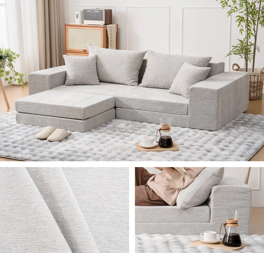 グレーの布張りのソファと、コーヒーセット、スリッパ、植物が置かれた部屋の写真です。