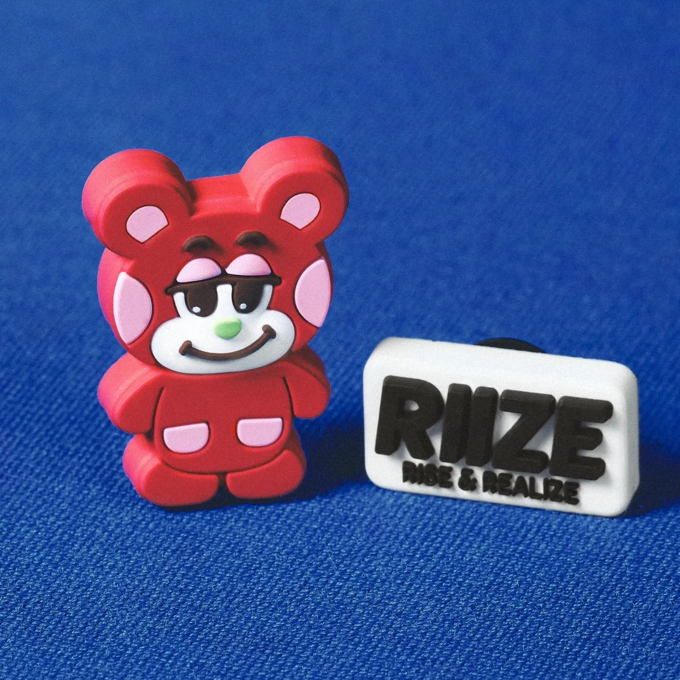 赤いクマのキャラクターとRIIZEのロゴのジビッツ